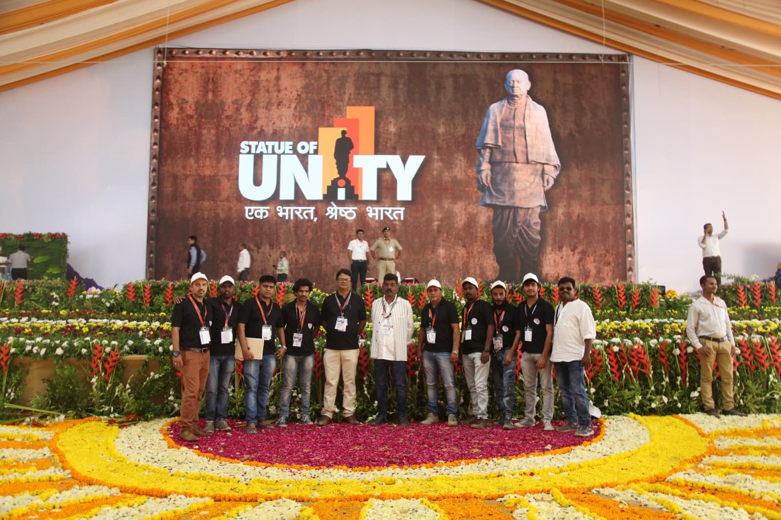 Wide view of the Statue of Unity event stage with the crew and floral installation